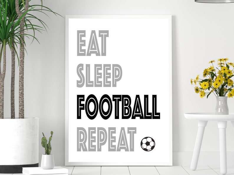 May include: Black and white print with the text "Eat Sleep Football Repeat" and a black and white soccer ball.