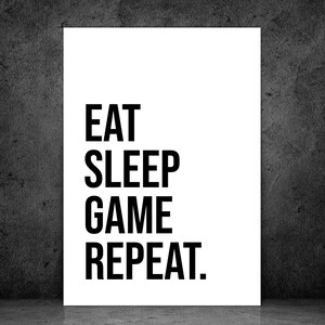 May include: A white poster with black text that reads "EAT SLEEP GAME REPEAT."