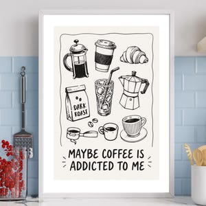May include: A framed wall art print featuring black line drawings of coffee-related items including a French press, a coffee cup, a croissant, a bag labelled DARK ROAST, an iced drink, and a moka pot, with the text MAYBE COFFEE IS ADDICTED TO ME.
