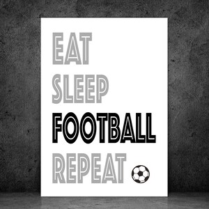 May include: Black and white print with the text "Eat Sleep Football Repeat" and a black and white soccer ball.