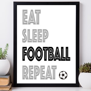 May include: Black and white framed print with the text "Eat Sleep Football Repeat" and a black and white soccer ball.