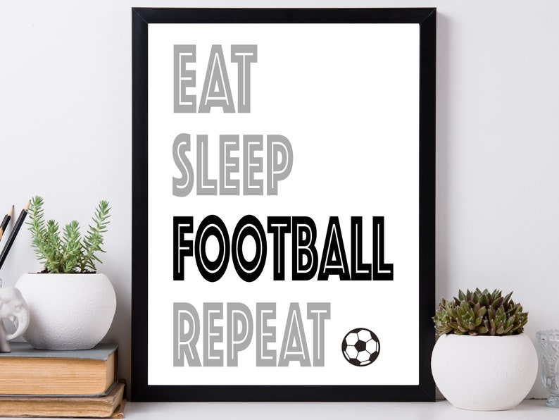 May include: Black and white framed print with the text "Eat Sleep Football Repeat" and a black and white soccer ball.