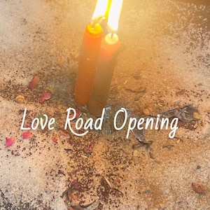 May include: Two orange candles with bright flames are lit, set in a bed of sand and dried flowers. The text "Love Road Opening" is written across the bottom of the image.