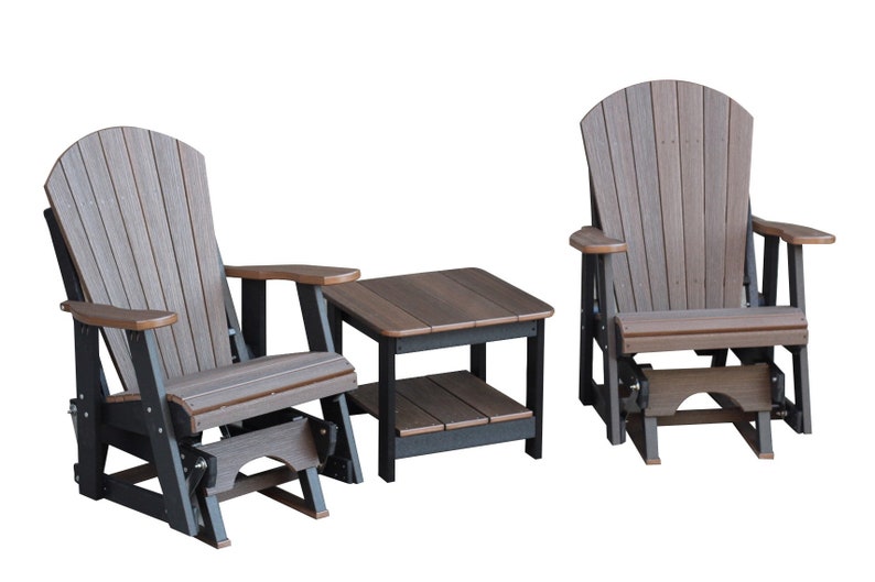 May include: A set of two brown and black Adirondack-style gliders with a matching brown and black side table. The gliders have a slatted back and seat, and the table has a shelf.