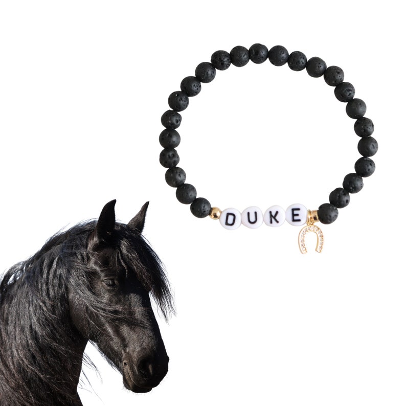 May include: Black lava rock bracelet with gold beads and white letter beads spelling "DUKE" and a gold horseshoe charm.