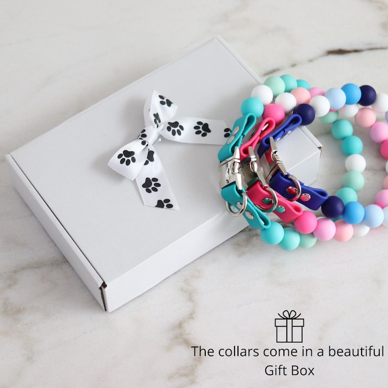 May include: Three colorful dog collars with silver buckles come in a white gift box with a black paw print ribbon. The collars come in a beautiful gift box.