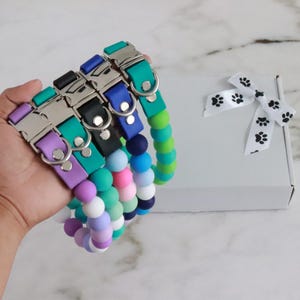 May include: Five colorful silicone dog collars with silver buckles and a matching silicone beaded collar in shades of blue, green, and purple.