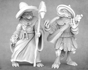 May include: Two painted figurines of anthropomorphic foxes. One fox is wearing a wizard's robe and hat, holding a staff. The other fox is wearing a bard's outfit and playing a lute.