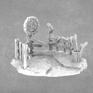 Könnte beinhalten: Eine 3D-gedruckte Miniatur eines hölzernen Bogenschießplatzes mit einer Zielscheibe, einem Zaun und einem Köcher mit Pfeilen. Die Miniatur ist in hellgrau bemalt.