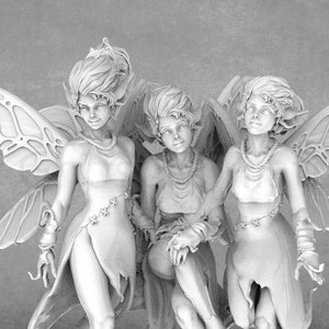 May include: Three white fairy figurines with wings, each wearing a flowing dress and jewellery. The fairies are posed in a group, with one sitting and the other two standing.