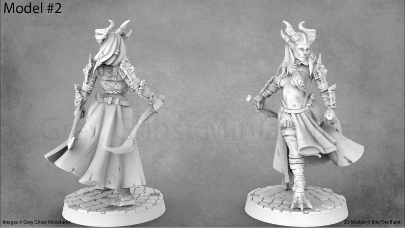 May include: A white painted miniature figurine of a female figure with horns, wearing a long robe and holding a dagger. The figure is standing on a circular base.
