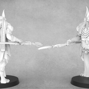 May include: A white plastic miniature figurine of an Egyptian god with a jackal head, wearing a traditional headdress and holding a staff. The figurine is standing on a black base. Model #3.