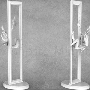 May include: A white, 3D printed model of a woman trapped inside a rectangular frame. The woman is contorted in a pose, with her head and arms extending outside the frame. The model is set against a gray background.