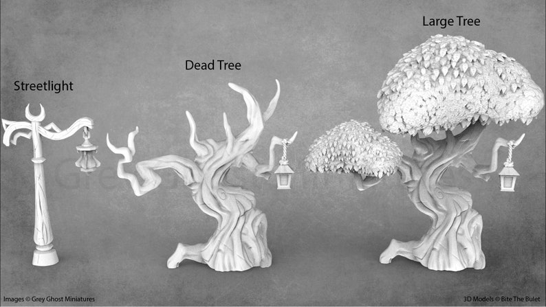 Op de afbeelding: Drie 3D-geprinte miniatuur bomen, een grote, een dode en een kleine, met een lantaarnpaal. Elke boom heeft een lantaarn die aan een tak hangt.