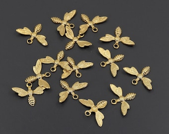 May include: A collection of 14 gold-toned bee charms with detailed wings and a loop for attaching to jewelry or crafts.