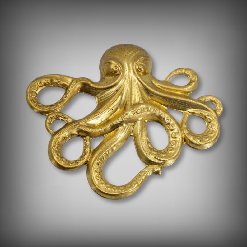 K&ouml;nnte beinhalten: Ein goldfarbener Metalloktopus mit acht Tentakeln. Der Oktopus ist mit strukturierten Ringen um jeden Tentakel verziert.