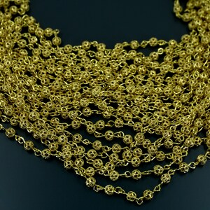 Puede incluir: Un collar de cadena dorada con peque&ntilde;os eslabones redondos e intrincados. La cadena est&aacute; hecha de metal y tiene un aspecto delicado y femenino.