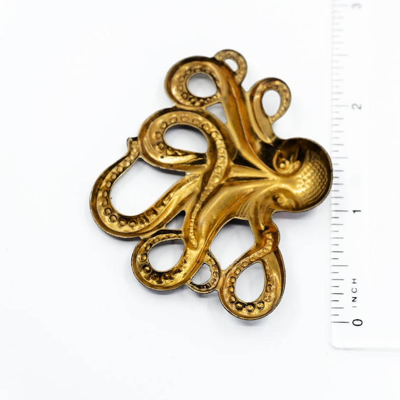 K&ouml;nnte beinhalten: Ein goldfarbener Metalloktopus mit detaillierten Tentakeln, perfekt, um Kunsthandwerk oder Schmuck einen maritimen Touch zu verleihen.