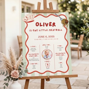 May include: A milestone birthday sign featuring a red wavy border on a light green striped background. It displays the text OLIVER IS ONE LITTLE MEATBALL, JUNE 6, 2025, 8:49 PM, 7 LBS 10 OZ, 21 IN, and details about the child's favorites and abilities.