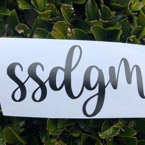 Peut inclure: Un autocollant blanc avec le texte "sssdlgm" écrit en cursive noire.