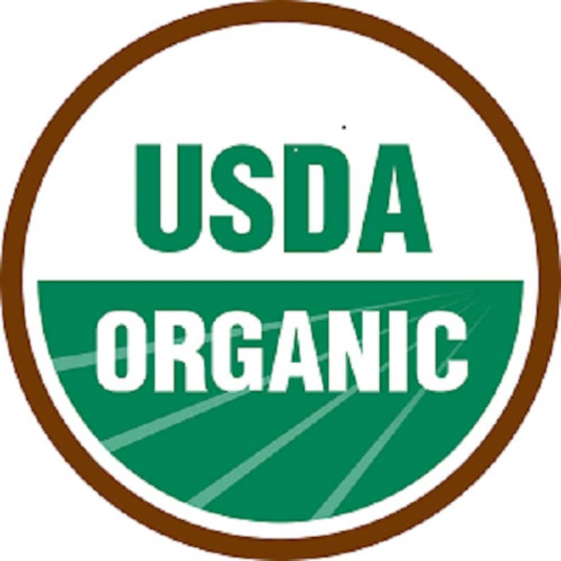May include: A circular USDA Organic seal with a brown border. The words "USDA" and "ORGANIC" are in bold, white letters. The background behind the words "ORGANIC" is green with white lines.