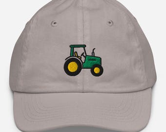 May include: A light gray baseball cap featuring an embroidered green tractor with yellow wheels. The tractor design is on the front of the cap, offering a simple, yet eye-catching design. The cap has a curved brim and an adjustable strap.