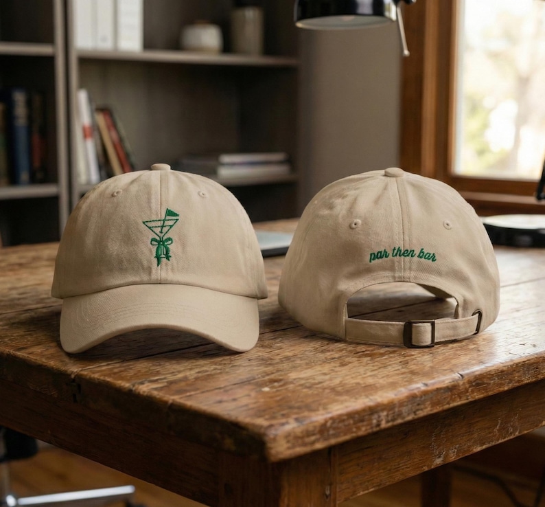 May include: Two tan baseball caps. One cap features a green embroidered cocktail glass design on the front. The other cap has the words "par then bar" embroidered in green on the back. Both caps have adjustable straps.