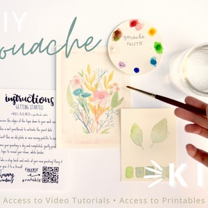 Op de afbeelding: Een DIY gouache-set met instructies, een palet, een penseel, een glas water en twee vellen papier met geschilderde bloemen en bladeren. De set bevat toegang tot videotutorials en printables.