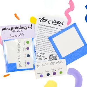 May include: A mini gouache painting kit with lavender paint and a dot card with six different colors: amethyst, gray, violet, pastel, sage, and a dark blue color. The kit includes instructions on how to get started with the paint.