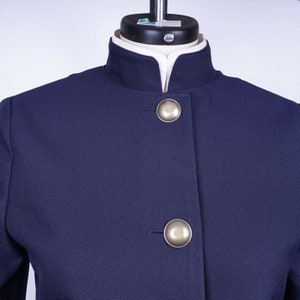 May include: A navy blue blazer with a mandarin collar and two silver buttons.