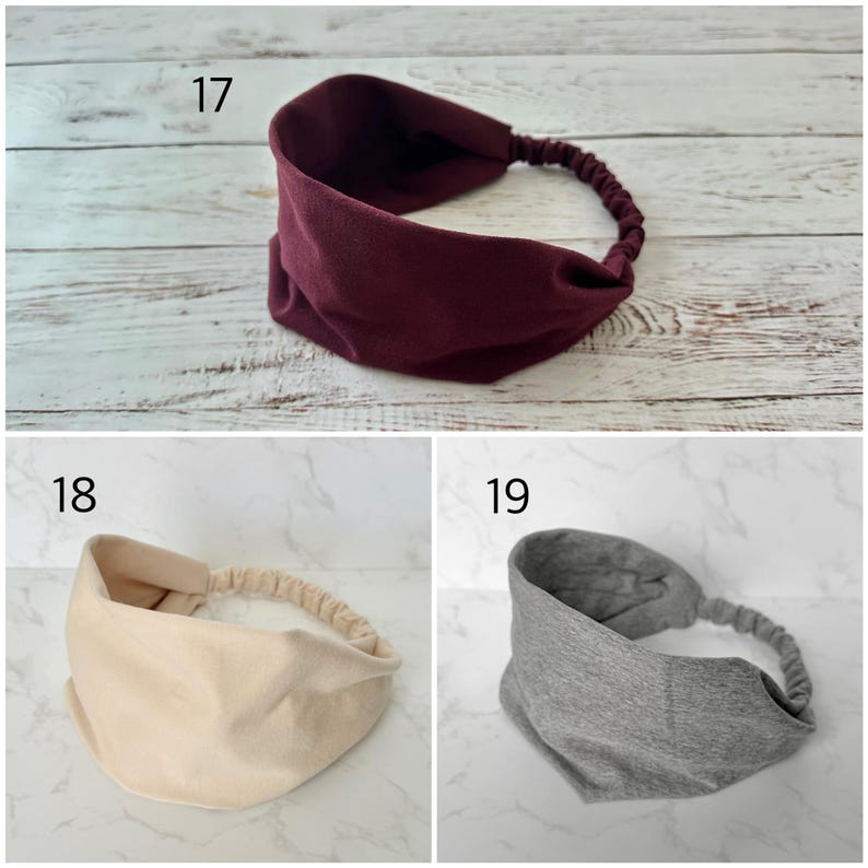 May include: Three fabric headbands labeled 17, 18, and 19. Number 17 is a deep burgundy, 18 is a light cream, and 19 is a heather gray. Each headband features a wide, solid-colored front section and a gathered elastic band at the back.