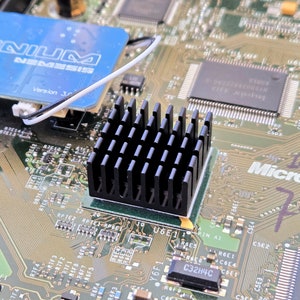 May include: A close-up of a circuit board with a black heat sink, a blue and white card with the text "Xenium Nemesis Version 3.0", and the text "Microsoft 1473 732".