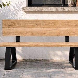Könnte beinhalten: Eine Holzbank mit einer Sitzfläche und Rückenlehne aus hellbraunem Naturholz, die von zwei schwarzen A-förmigen Metallbeinen getragen wird. Die Rückenlehne besteht aus zwei horizontalen Holzplanken und die Sitzfläche aus einem Brett.