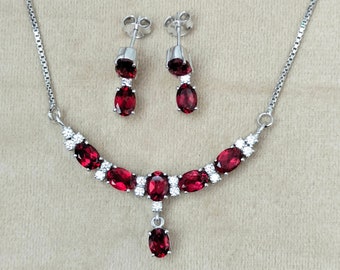 Peut inclure: Un collier et des boucles d'oreilles en argent avec des pierres précieuses ovales rouges et de petites pierres claires.