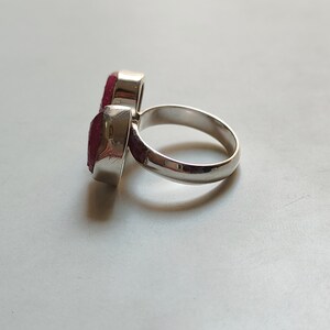 Peut inclure: Une bague en argent avec deux pierres pr&eacute;cieuses rouges. La bague est con&ccedil;ue pour &ecirc;tre port&eacute;e sur la phalange de l'index.