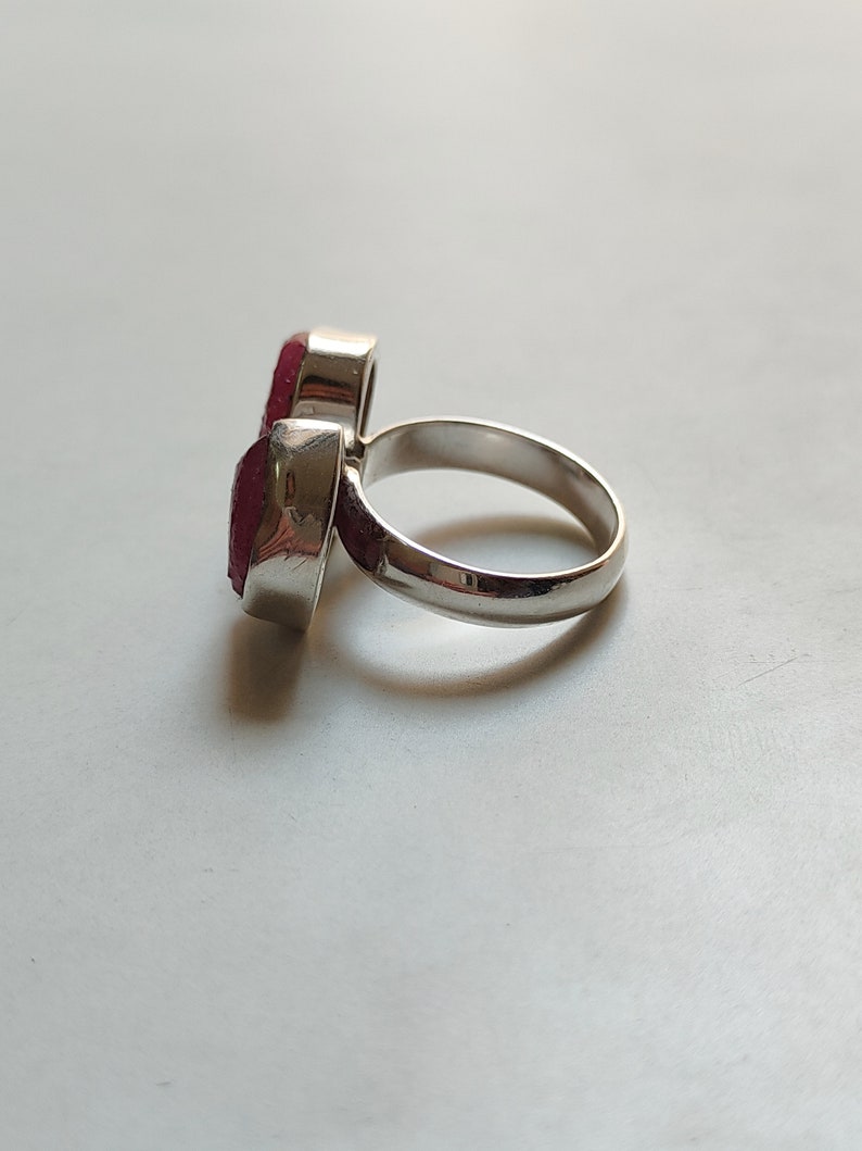 Peut inclure: Une bague en argent avec deux pierres pr&eacute;cieuses rouges. La bague est con&ccedil;ue pour &ecirc;tre port&eacute;e sur la phalange de l'index.