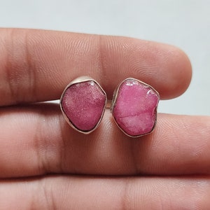 Peut inclure: Une paire de boucles d'oreilles en argent avec des accents de pierres pr&eacute;cieuses roses. Les pierres pr&eacute;cieuses sont de forme irr&eacute;guli&egrave;re et ont un aspect brut et naturel.