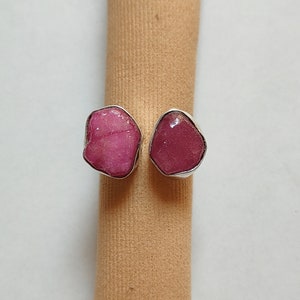 Peut inclure: Une bague en argent avec deux pierres pr&eacute;cieuses roses. Les pierres pr&eacute;cieuses ont une forme irr&eacute;guli&egrave;re et un aspect brut et naturel.