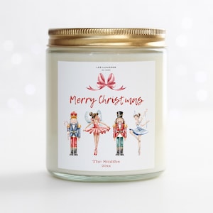 Può includere: Una candela in barattolo di vetro con coperchio dorato. L'etichetta recita "Merry Christmas" con illustrazioni di uno schiaccianoci, una ballerina e un fiocco. La parte inferiore dell'etichetta dice "The Smiths" e l'anno "20xx".