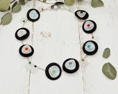 auffällige Kette schwarz weiß, kombiniert mit Regenbogenfarben mit Scheiben, Kunststoffblumen und Blättern