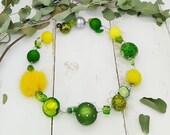 extravagante Statement Kette mit Polarisperlen, Puschel, Resin und Muranoglas in grün und gelb