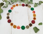 elegante Kette mit Rosen, Schnecken und Polaris in Kontrastfarben