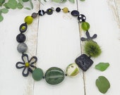 extravagante Kette mit Puschel, Blumen und edlen Lavaelementen