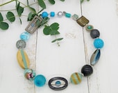 extravagante Kette mit Drahtschlingen im Materialmix