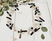 edler Halsschmuck mit silberfarbenen Ringen und verschiedenen Naturmaterialien