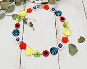 fröhliche Kette mit Blümchen, Schnecken und Polariselementen in Regenbogenfarben