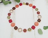 elegante Kette im Materialmix mit goldenen Rosen und Polariselementen