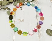 fröhliche Kette mit Blümchen, Schnecken und Resin in Regenbogenfarben