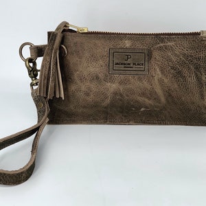 Jackson Place Collection - Bolso de mano de piel de vaca con borlas pequeñas y cierre de cremallera, con etiqueta de vaca y correa extraíble, color gris