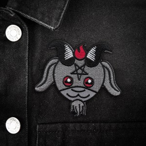 May include: A black denim jacket with a gray and red embroidered patch of a cartoon goat with horns, a pentagram, and red eyes.
